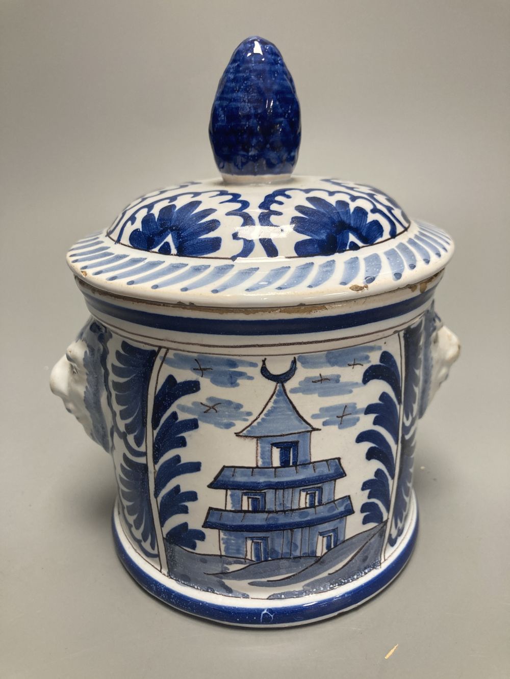 An 18th/19th century Delft blue and white jar and cover, with bearded mask handles, 17cm